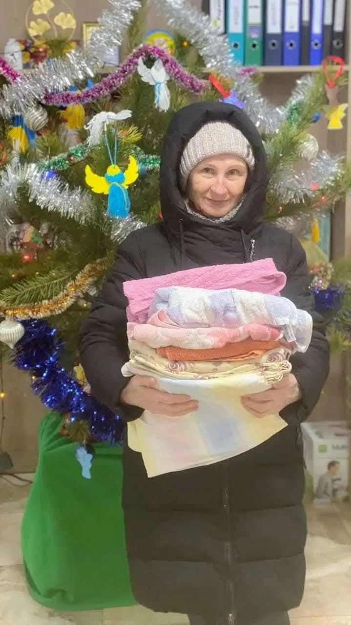 Lady receiving blankets, towels and basic humanitarian aid